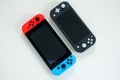 A multiplayer Nintendo Switch and single player Nintendo Switch Lite gaming consoles side by side