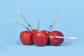 Multiple apple fruits being injected with syringes. Concept for genetically modified organism