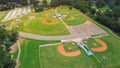 Multiple baseball, softball fields with batting cages, stadium seating in giant sport complex near residential neighborhood,