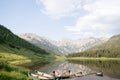 Multiple canoes lined up on the shoreline of a tranquil lake, surrounded by a picturesque landscape Royalty Free Stock Photo