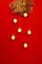 Multiple Christmas gold baubles and pine tree branches creative decoration pattern on the red background