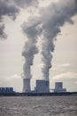Multiple coal fossil fuel power plant smokestacks emit carbon