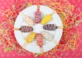 Popsicle cake pops on a plate pink background with party streamers