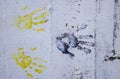 Multiple colored hand prints on white dirty wall