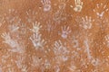 Multiple colorful children hand prints on huskily brown wall Royalty Free Stock Photo