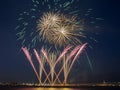 Multiple colorful fireworks burst in the night sky with light trails and golden circles of fireworks Royalty Free Stock Photo