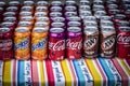 Multiple colorful sodas on an outdoor tablecloth