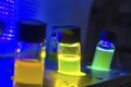 Multiple colourful close up light induced catalyst photochemical reaction in glass vial under UV light in a dark chemistry