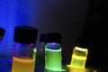 Multiple colourful close up light induced photochemical reaction in glass vial under blue UV light in a dark chemistry laboratory