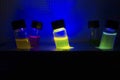 Multiple colourful light induced catalyst photochemical reaction side view in glass vial under UV light in a dark chemistry