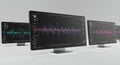 Multiple computer monitors displaying complex line graphs with a dark background Royalty Free Stock Photo