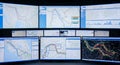 Multiple computer screens displaying maps and data visualizations in a control center Royalty Free Stock Photo