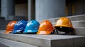 Multiple construction helmets of various colors placed together on a concrete surface in outdoor setting Royalty Free Stock Photo