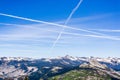 Multiple contrails cross paths through the blue sky above snow capped mountains; Yosemite National Park, Sierra Nevada mountains,