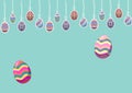 Multiple decorative colorful easter eggs hanging to string with copy space against green background