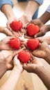 Multiple diverse hands gently holding red heart shapes together expressing unity Royalty Free Stock Photo