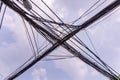 Multiple electric wires crossing in the air against blue sky, view at a street of Hanoi, Vietnam.