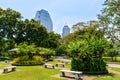 Multiple empty benches in Lumpini city park, view at Bangkok skyscrapers Royalty Free Stock Photo