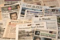 Multiple European newspapers in a pile