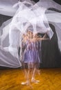 Multiple exposure of ballerina in purple, dancing with white fabric