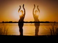 Multiple exposure of dark glowing silhouette of slim tribal dancer near big river