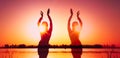 Multiple exposure of dark glowing silhouettes of slim woman in traditional tribal belly dance costume in front of red sky Royalty Free Stock Photo