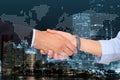 Multiple exposure of partners shaking hands, coins and city. Business values