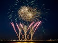 Multiple fireworks burst in the night sky with light trails and golden circles of fireworks Royalty Free Stock Photo