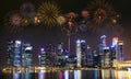 Multiple fireworks exploding high in the sky over modern building in city. Royalty Free Stock Photo