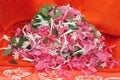 Flowers pile and heap in a orange background. Pile consists of a tulsi leaves, ganagale, lotus and sugandaraja flower