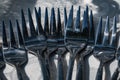 Multiple forks on a gray tablecloth