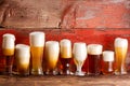 Multiple frothy beer pints on rustic wooden bench Royalty Free Stock Photo