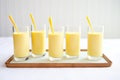 multiple glasses of mango lassi lined up for a party served with short straws Royalty Free Stock Photo