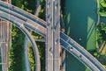 Aerial view of multiple highways intersect above a calm river, surrounded by vibrant greenery. Royalty Free Stock Photo