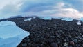 Multiple ice rocks and black rocks over black sand beach at Diamond beach Iceland