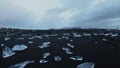 Multiple ice rocks over black sand beach at Diamond beach Iceland