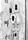 Multiple keyholes with rusted nails and spiderweb closeup monochrome