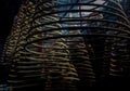 Multiple large yellow incense coils hanging in stacks from the Ceiling in a Chinese shrine