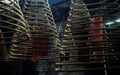 Multiple large yellow incense coils hanging in stacks from the Ceiling in a Chinese shrine
