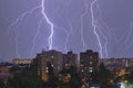 Multiple lightning strikes and thunderstorm over city buildings, at night. Weather phenomena Royalty Free Stock Photo