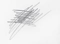 Multiple linear pencil scratches on blank paper surface.