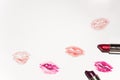 Multiple lipsticks and colorful kiss mouths on white background