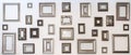 Multiple many blank small picture frames on white wall