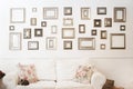 Multiple many blank small picture frames on white wall