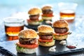 Multiple mini beef hamburgers with small beers