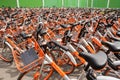 Multiple Orange Rental Bicycles crowded street side Shanghai China Friday, April 7, 2017