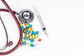 Multiple pills, tablet, caplet, capsule with stethoscope, and syringe. Healthcare concept Royalty Free Stock Photo