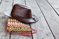 Multiple pipes pan flute and leather cowboy brown hat lying on square-edged flooring, copy space Royalty Free Stock Photo