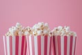 Multiple popcorn boxes with cascading kernels on a pink background, perfect for movie gathering