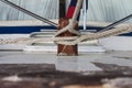 Multiple ropes tied to wooden cleat on vintage wooden boat